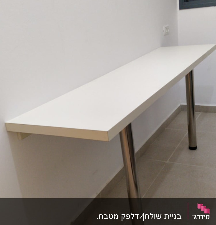 שולחן עם רגלי מתכת על רצפה אפורה